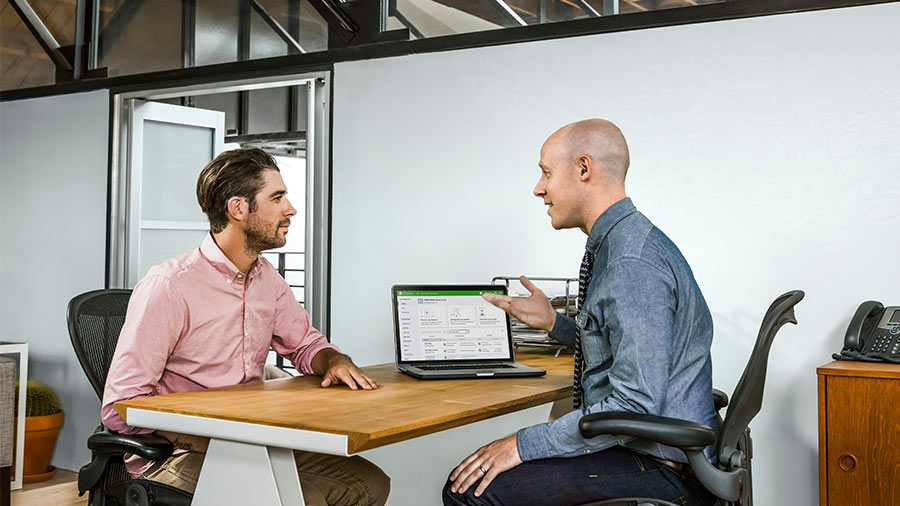 A person sitting at a desk with a laptop computer.