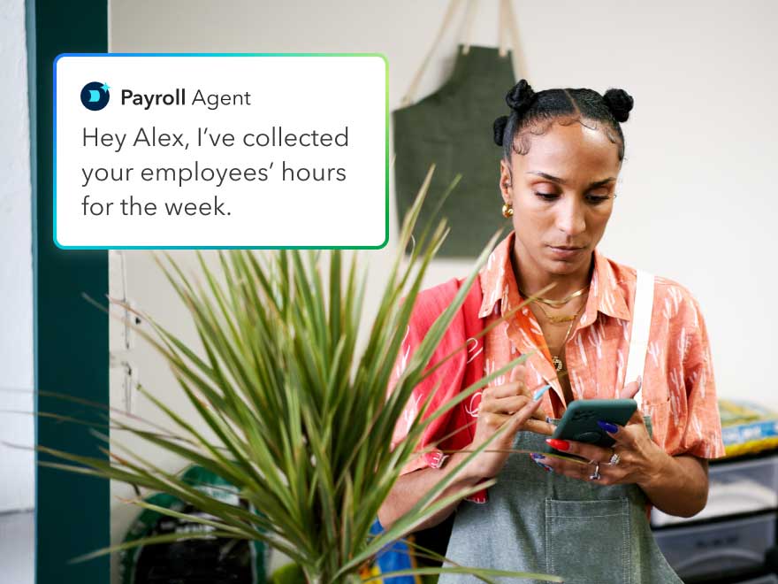 A person is on her phone next to a picture of flowers.