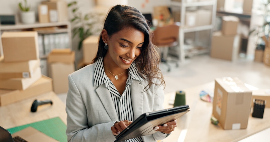 Businesswoman managing her firm's inventory on a device.