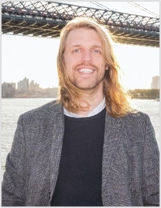 A person in a suit and tie standing in front of a building.