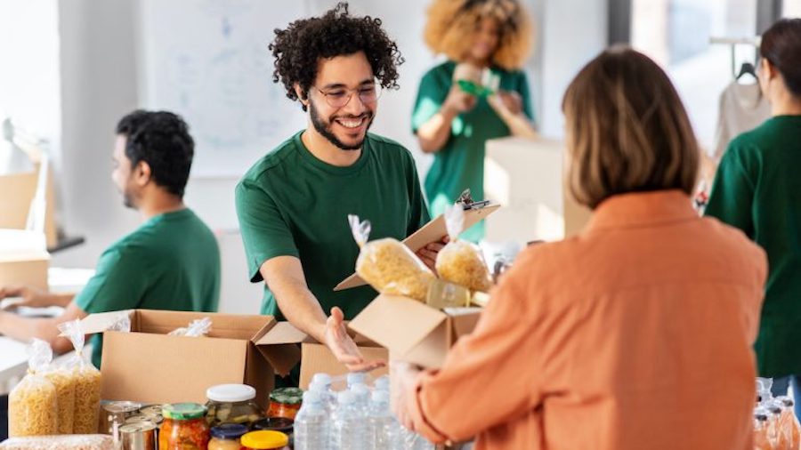 A group of people standing around a table with food.