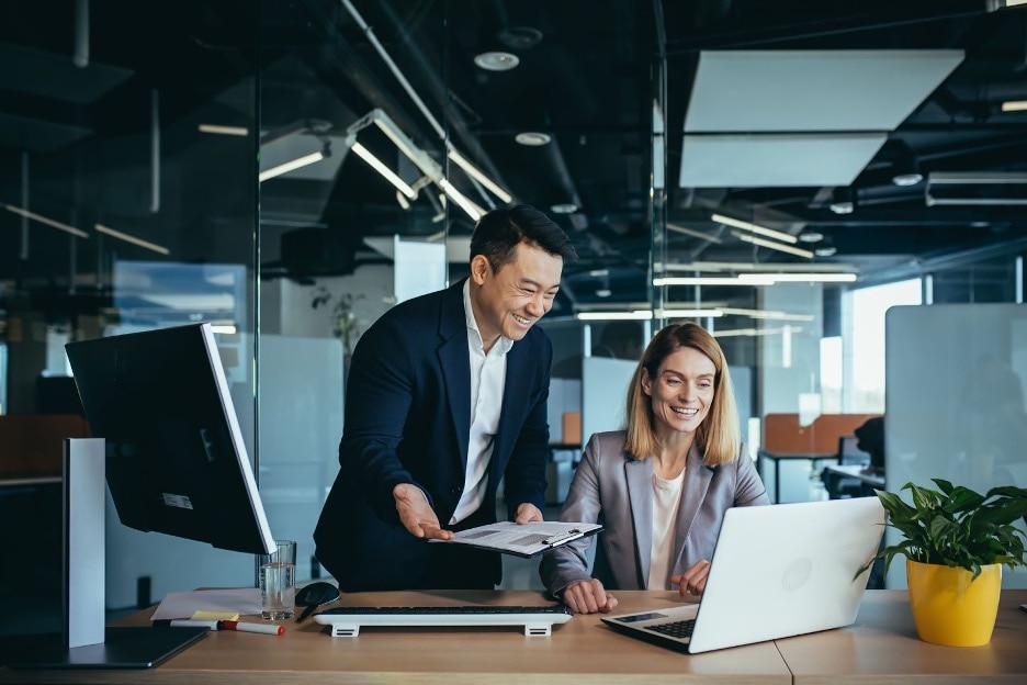 A person and person are looking at a laptop.