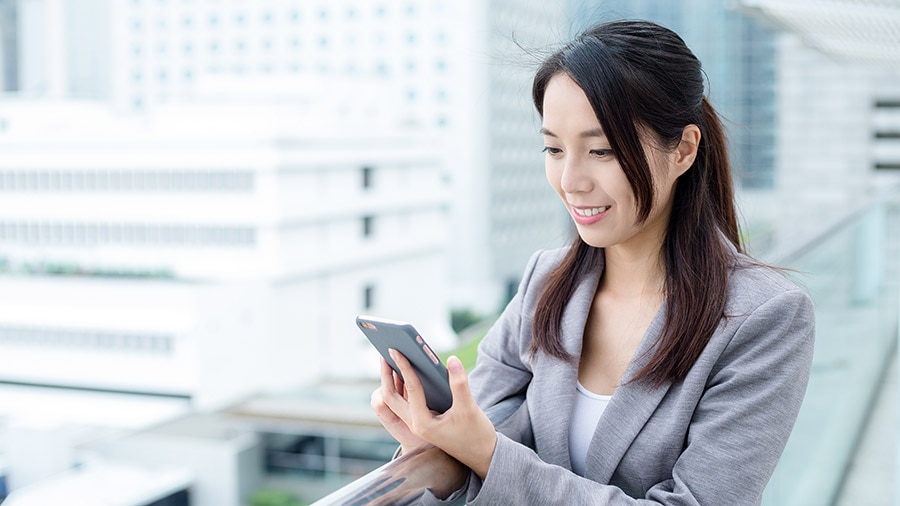 A person in a suit holding a cell phone.