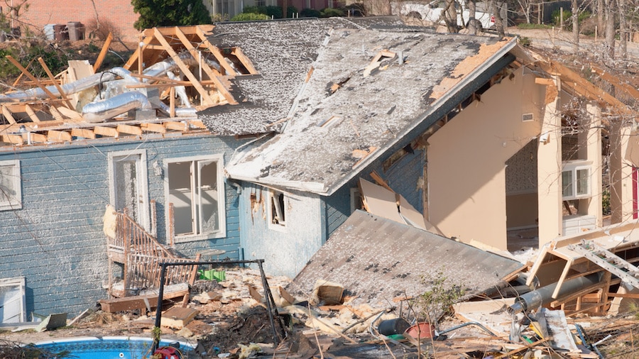 A house with a lot of junk in the back.