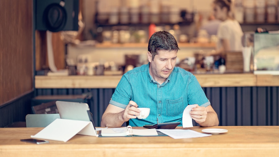 A person sitting at a table with a cup of coffee.