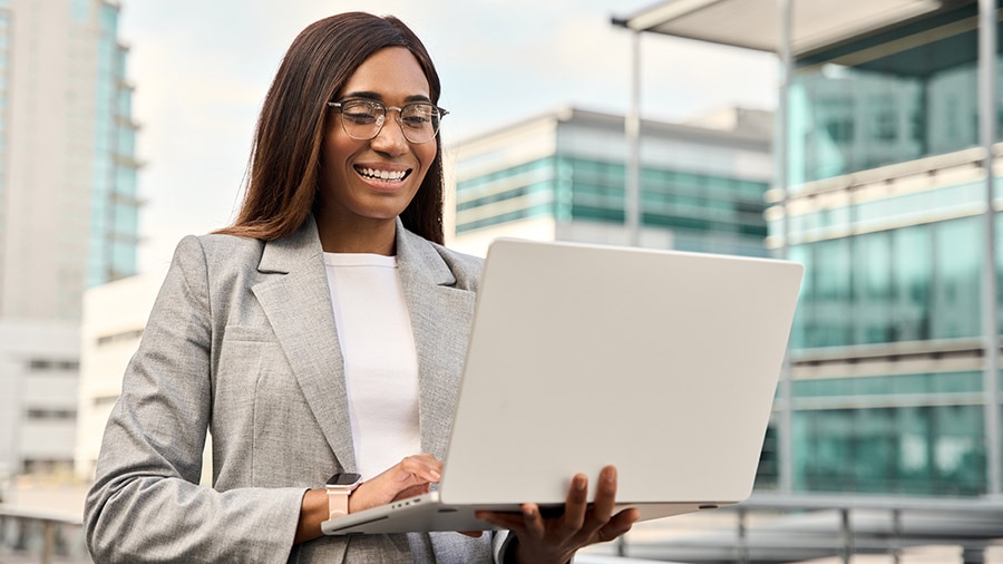 A person in a white shirt and black tie holding a laptop.