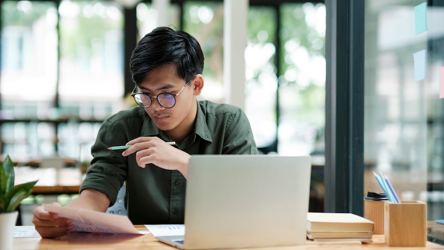 A person sitting at a table with a laptop computer.