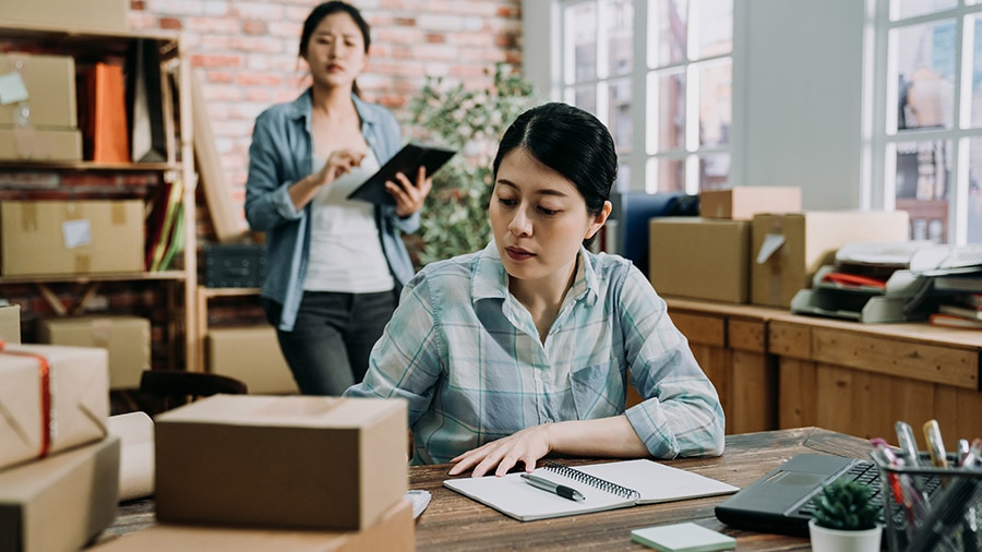 A person sitting at a desk with a laptop doing year-end payroll reporting