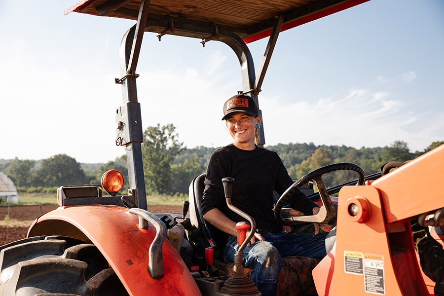 A person in a hat is sitting on a tractor.
