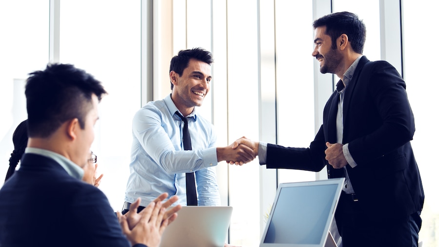 Two businessman showing proper etiquette by shaking hands. 