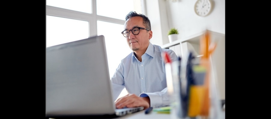 Businessman reviewing client advisory services on his laptop.