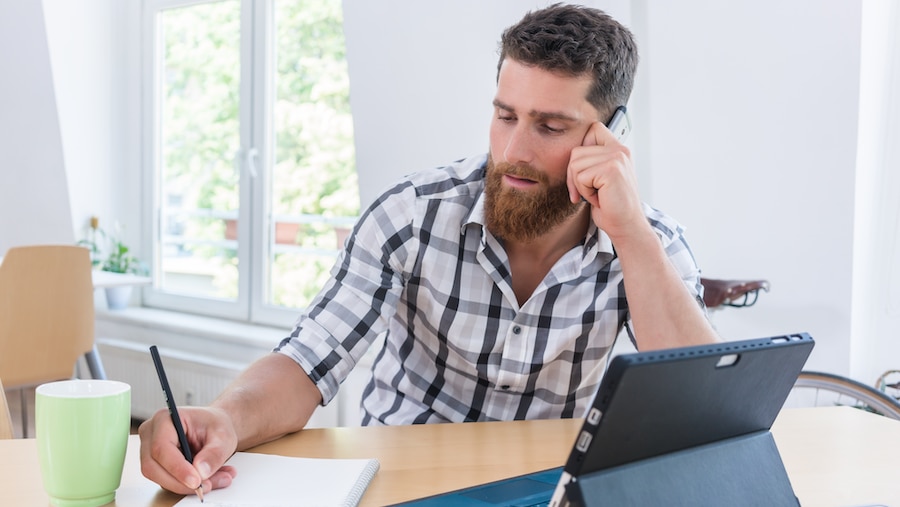 An independent contractor making a phone call and taking notes.