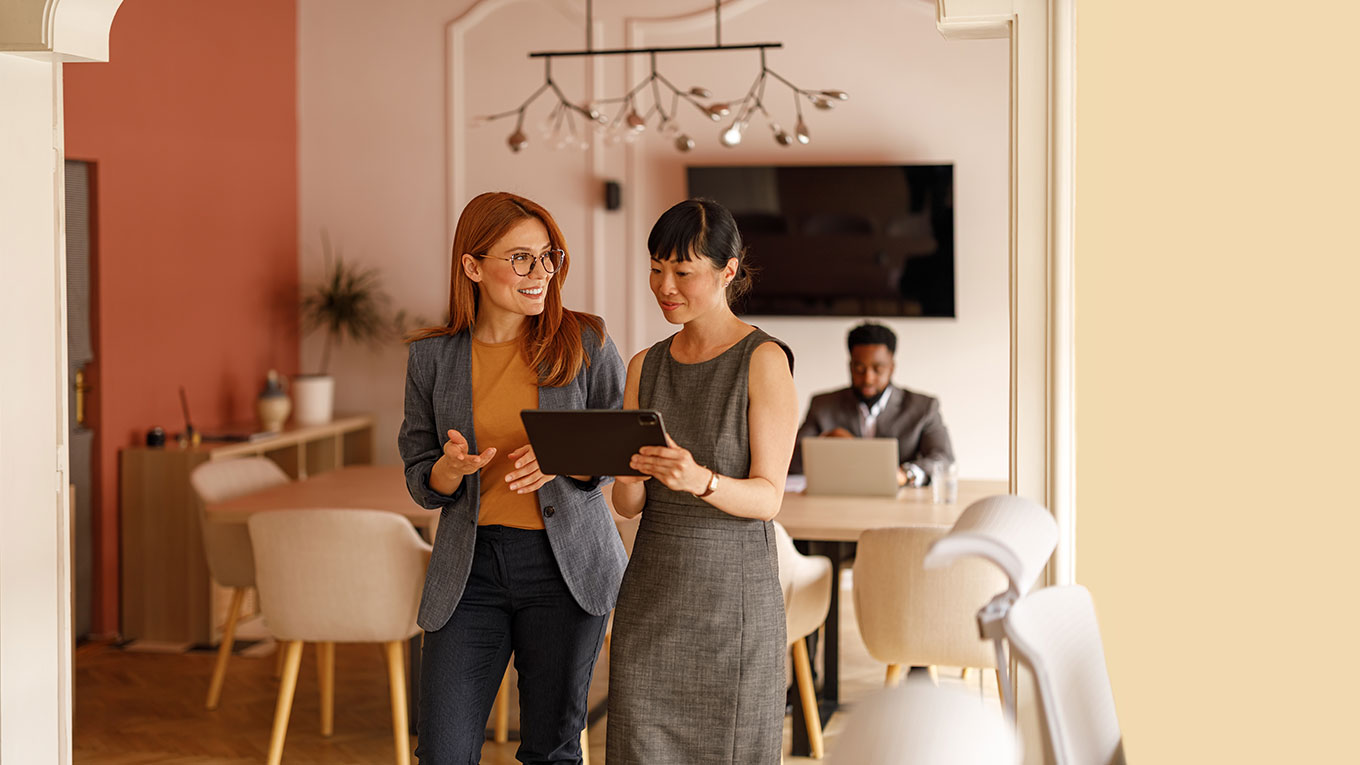 Two accounting professionals looking at a tablet reading about QuickBooks Online