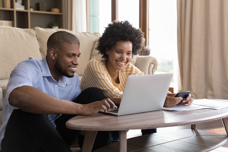 Two people happy to get paid quickly on their laptop.