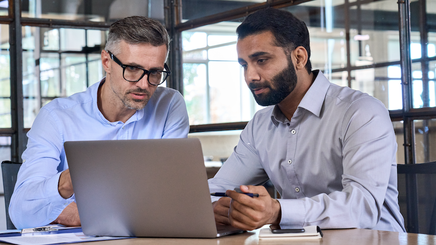 Two businesspeople looking at QuickBooks client overview.