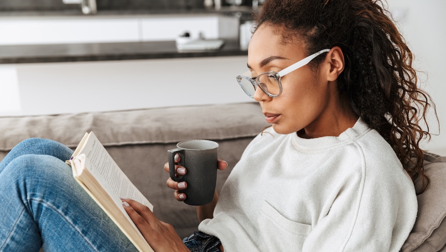 A woman reading a book in her office.