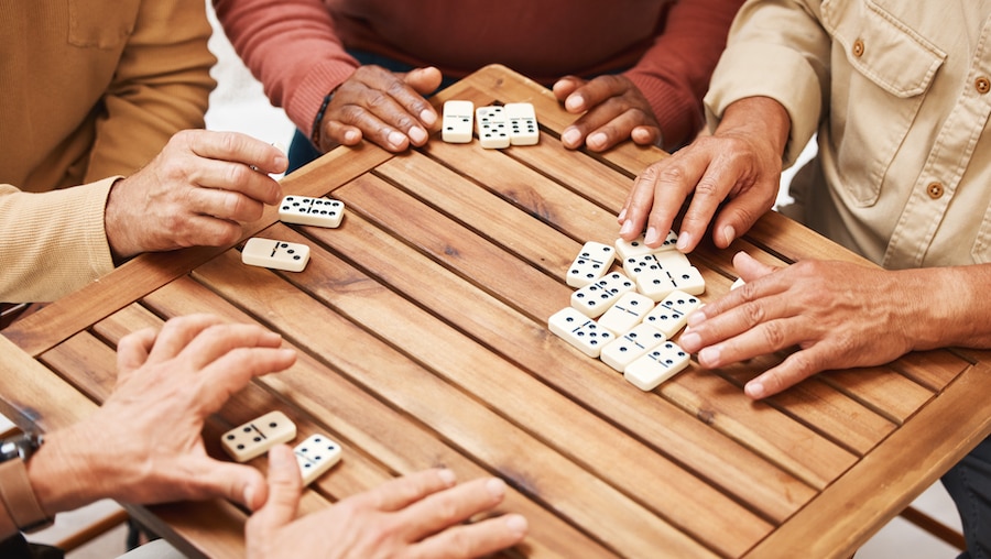 A group of people playing dominoes.