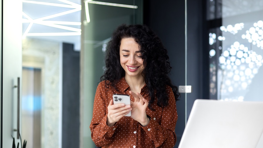 A businesswoman looking an apps on her phone.