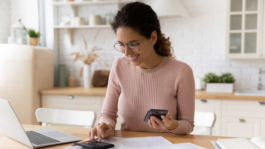 Bookkeeper reviewing finances on her calculator.