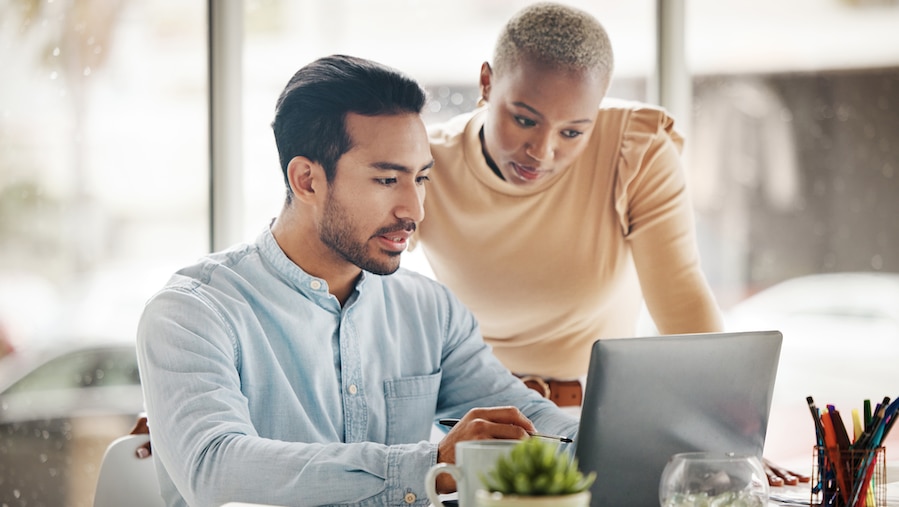 Two people looking over data on their computer.