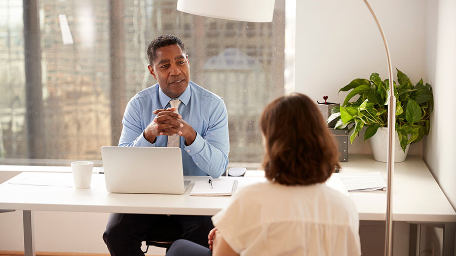 A person sitting at a table with a laptop computer.