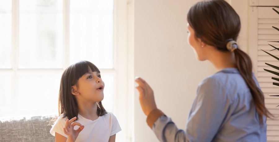 Mom and daughter practice sign language at home Image Alt Text