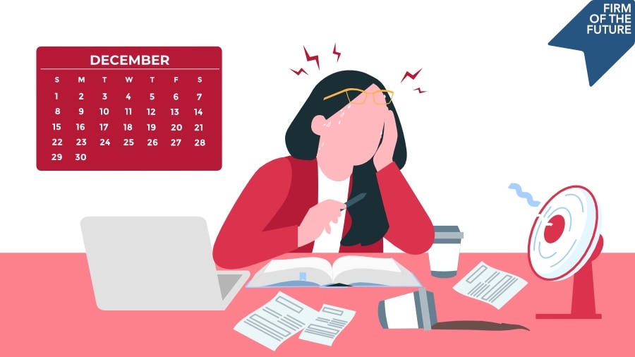 Stressed woman at desk in December, surrounded by documents, a calendar, a laptop, and a fan.