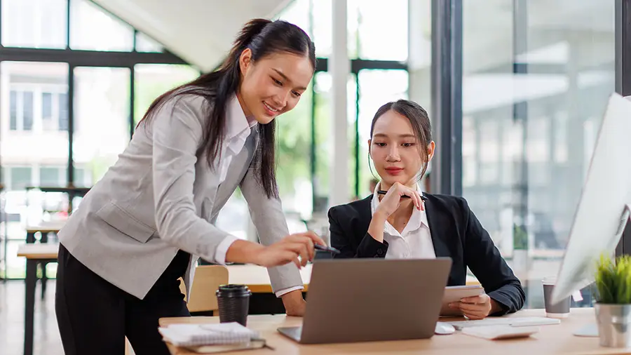 Two people are talking in an office setting.